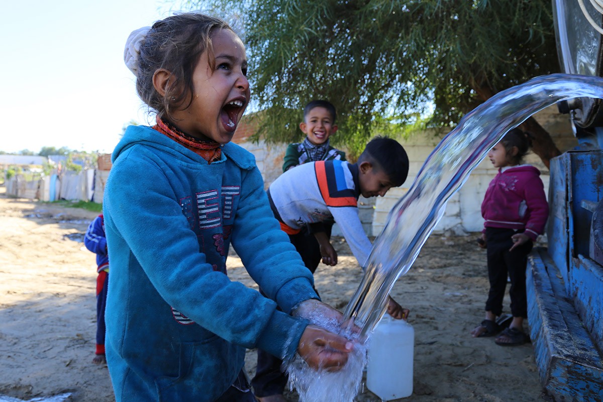 Palestinian girl washes hands with clean water