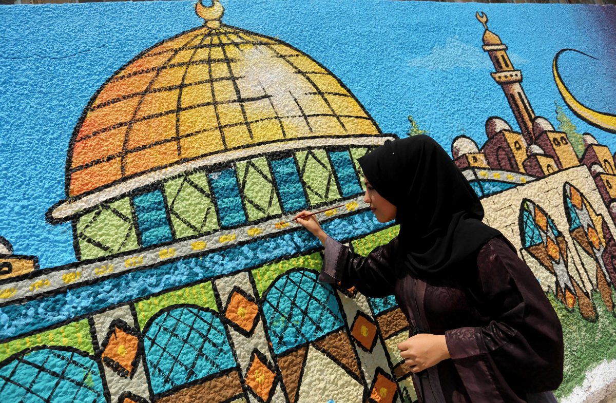 A Palestinian artist paints a mural drawing depicting the Dome of the Rock Mosque in Gaza city on July 25, 2017 [Ashraf Amra / ApaImages]