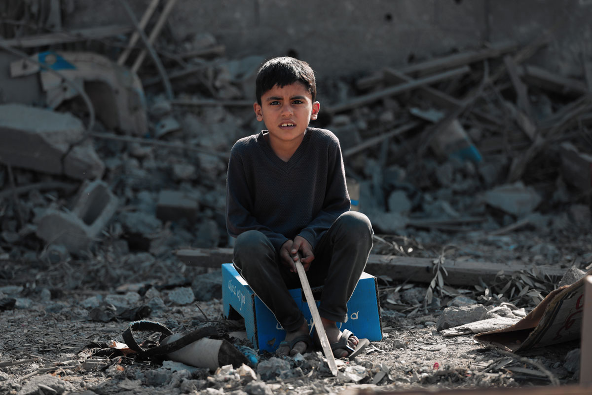 Interpal - Gaza boy sits in rubble